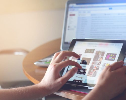 gambar seseorang sedang memakai tablet untuk cek sesuatu. Gambar ini dipakai untuk featured image artikel membahas website bisnis di Portofolio Jeremi Napoli Siregar.